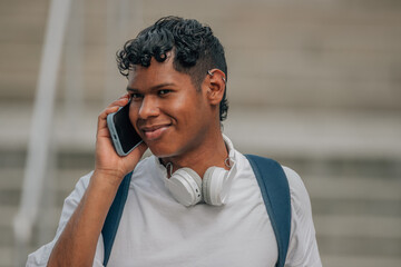 young latino male in the street talking on the mobile phone