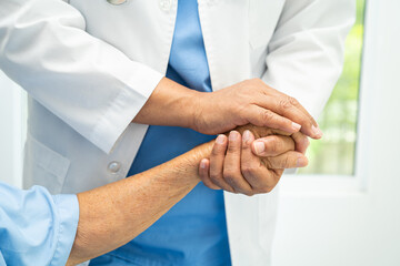 Caregiver holding hands Asian elderly woman patient with love, care, encourage and empathy at nursing hospital, healthy strong medical concept.