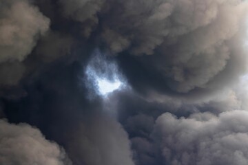 Low angle shot of dark stormy clouds in the sky with an eye space in the center