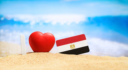 I love Egypt. Flag of Egypt on the beach with a red heart. vacation and travel concept.