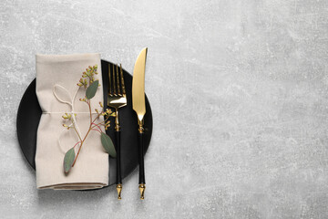 Stylish table setting with cutlery and eucalyptus leaves, top view. Space for text