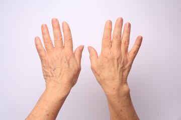 Closeup view of older woman's hands on white background