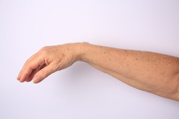 Closeup view of older woman's hand on white background