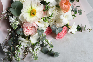 Bouquet of beautiful flowers on light grey table, above view