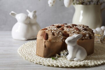 Delicious Italian Easter dove cake (Colomba di Pasqua) and festive decor on white wooden table. Space for text
