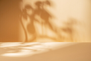 Empty table on bright brown wall background. Composition with tree shadow on the wall. Mockup...