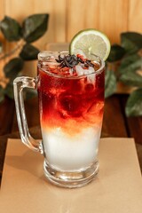 Vertical image of a vibrant and colorful cocktail beverage with an lemon slice garnish