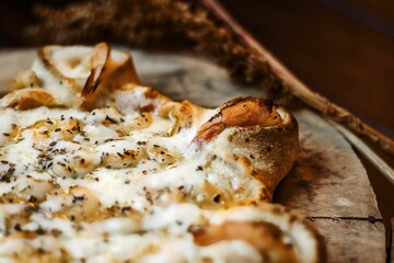 there is a pizza that has cheese on it at the table