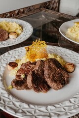 Delicious steak and assorted vegetables served on a white plate, ready to be enjoyed