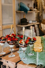 Array of delicious strawberry and chocolate covered desserts is displayed on a table