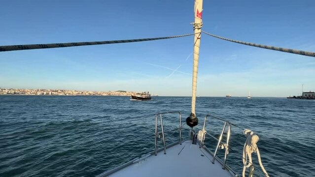Scenic view of ship sailboat sailing in Lisbon, Portugal with buildings on the shore