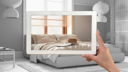 Augmented reality concept. Hand holding tablet with AR application used to simulate furniture products in custom architecture design, total white background, japandi bedroom