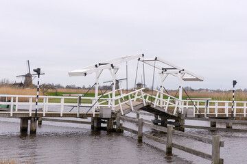 Fototapeta na wymiar Wooden bridge across a canal in Kinderdijk. Holland