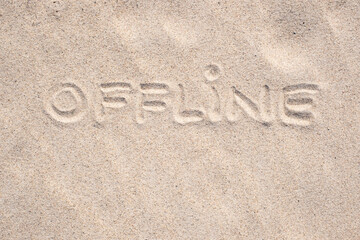 Sand background. Word Offline written on sand. Sandy beach. Blank negative space for copy. Summer holiday banner.
