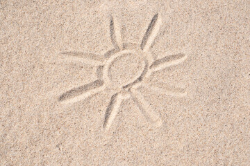 Sand background. Simple image of sun drawn on sand. Sandy beach. Blank negative space for copy.