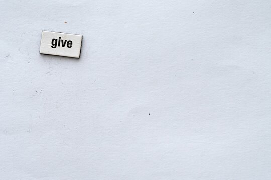 The Word Give Written On White Background With Fridge Magnet