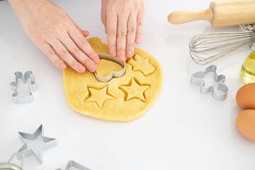 Woman preparing gingerbread cookies on white table at kitchen . Female hands cutting ginger dough with cutter to making cookies for winter holidays.copy space. Banner