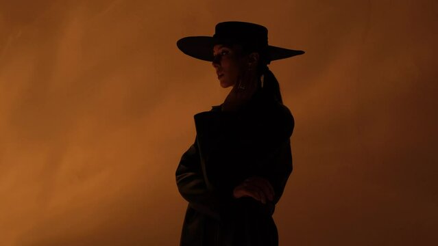 Fashion portrait of a girl in the studio with a black hat with golden decorations. Jewelry.