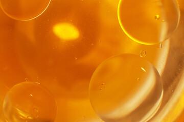Gold Oil bubbles close up. circles of orange water macro. abstract shiny yellow background