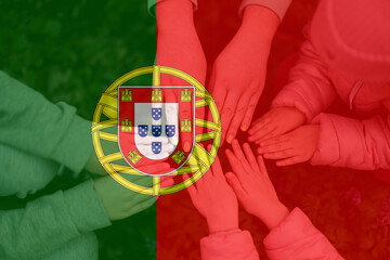 Hands of kids on background of Portugal flag. Portuguese patriotism and unity concept.