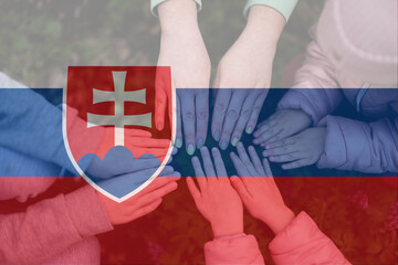 Hands of kids on background of Slovakia flag. Slovakian patriotism and unity concept.