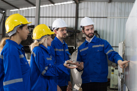 Group of male and female worker meeting, discuss, training and present of work on whiteboard in factory