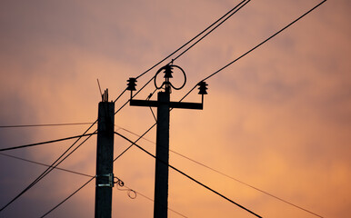 Electric pole with wires on the background of the sunset