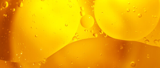 Gold Oil bubbles close up. circles of orange water macro. abstract shiny yellow background