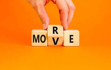 More move symbol. Concept word More move on wooden cubes. Beautiful orange table orange background. Businessman hand. Business and more move concept. Copy space.