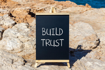 Build trust symbol. Concept words Build trust on black chalk blackboard on a beautiful stone...