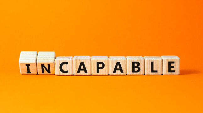 Capable or incapable symbol. Concept words Capable or Incapable on wooden cubes. Beautiful orange table orange background. Business capable or incapable concept. Copy space.