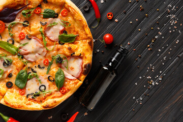 Pizza on a dark wooden background top view.