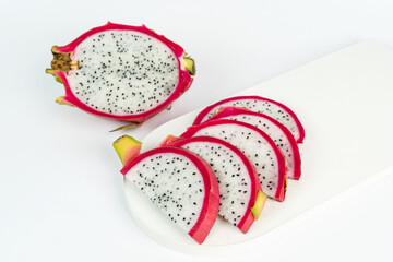 Tasty slices of dragon fruit lying on a white concrete tray. Vegan concept