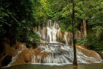 Scenic view of the Saiyok Yai waterfall in an evergreen forest in Thailand