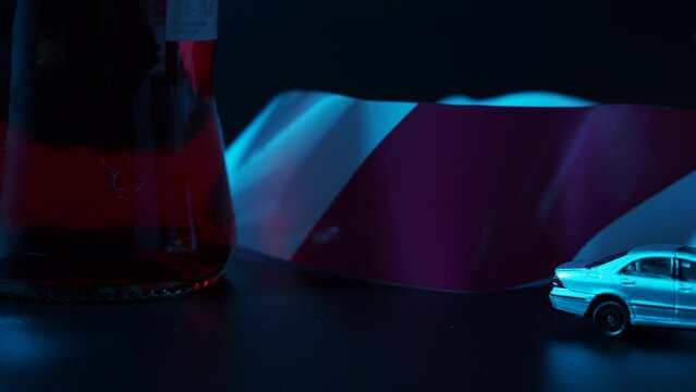 Mini car accident. Alcohol and a toy car on a dark background. Drunk driving warning.