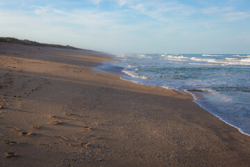 Sandy shoreline rolls into the sea