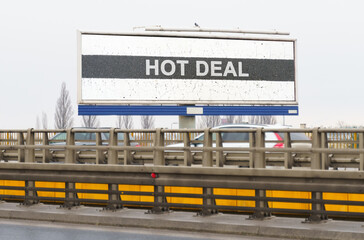 On the highway there is an advertising billboard with the image and the inscription - HOT DEAL