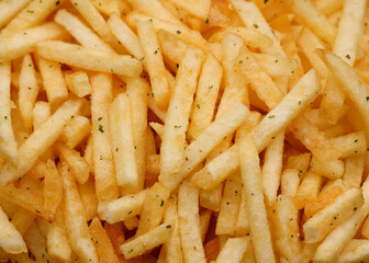 French fries background, closeup shot. Delicious potatoes with a golden fried crust. French fries background. Potato straw