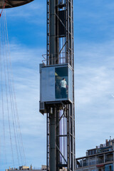 Tourists inside an exterior elevator with windows in the Las Arenas shopping center in Barcelona with people inside looking at the city from above and taking photos with their mobile phones.