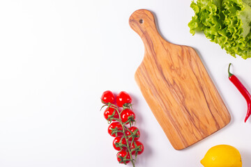 Wooden Cutting Board with Fresh Herbs and Raw Vegetables on Rustic Wood Table. Top view. Cooking...