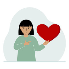 A girl holds a big red heart in his hand. The concept of volunteering, romantic relationship or love.