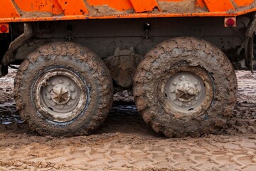Dirty truck wheels on yellow sand. close-up photo