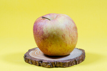 One apple on a yellow background.