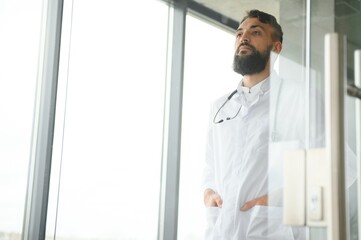 Fototapeta premium Portrait of pleasant young Arabian doctor in white coat.