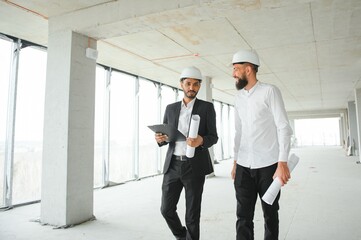 Multiethnic business team. Construction concept. Indian and Arab engineers inspect the construction.