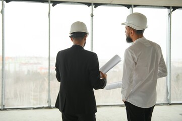 Multiethnic business team. Construction concept. Indian and Arab engineers inspect the construction.