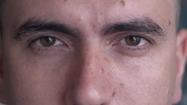 Close up of male face with moles. Natural beauty. Attractive young man opening his beautiful brown eyes