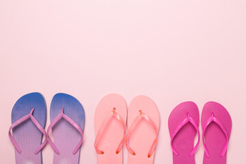 Many bright flip flops on color background, top view