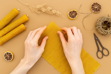 DIY - do it yourself concept. Hands making beeswax honey aroma candles - obrazy, fototapety, plakaty