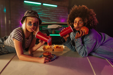 Diverse friends eating takeout outdoors.